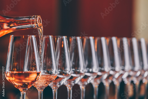 Fototapeta Naklejka Na Ścianę i Meble -  Wine glasses in a row. Pouring wine. Buffet table celebration of wine tasting. Nightlife, celebration and entertainment concept
