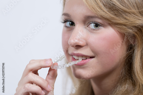 Junge Frau setzt Zahnspange ein