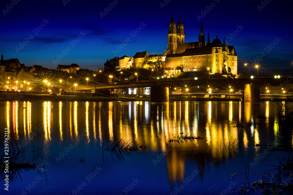 Panoramic night view over river Elbe at the Albrechtsburg in Meißen Germany with bright light reflections.