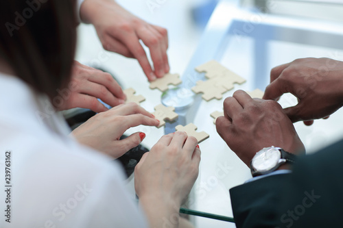 close up. business team assembling puzzle pieces. © yurolaitsalbert