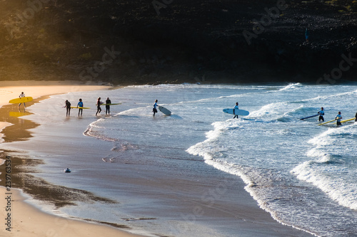 Photography group of young people at beach going surfing