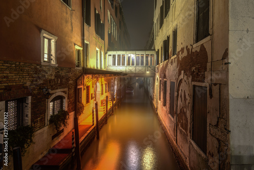 Historical buildings at narrow canal at night in Venice Italy.
