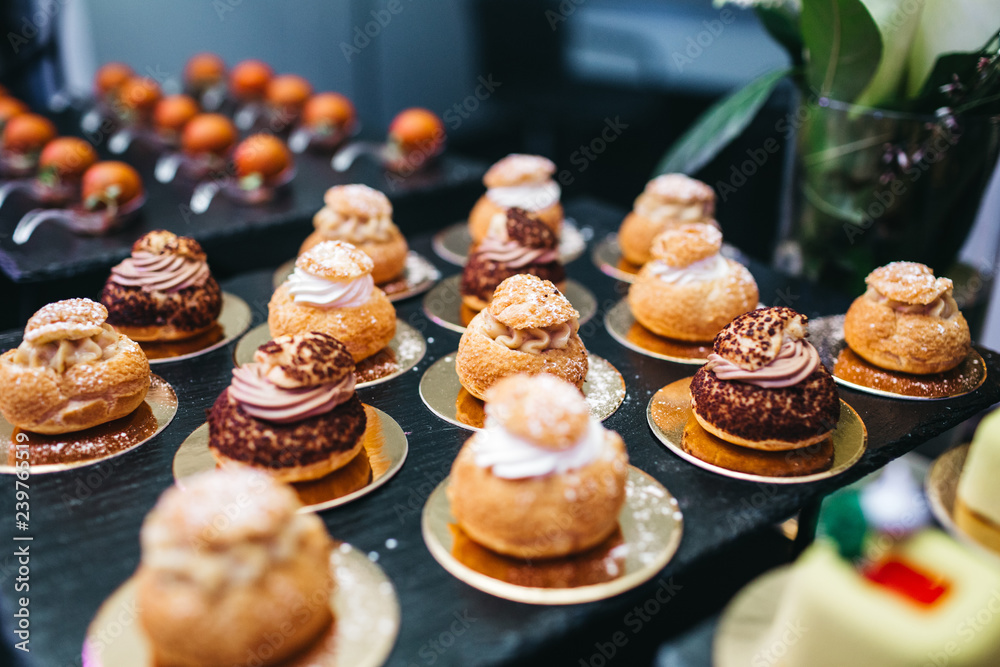 Beautifully decorated catering banquet table with profiteroles, salads and cold snacks. Variety of tasty delicious snacks on the table. Wedding table serving. Meat and vegetables