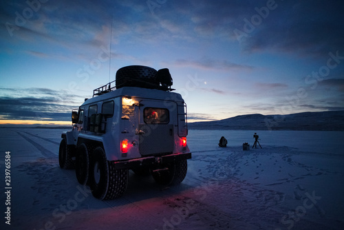 All-terrain vehicle on background of sunrise, winter season.