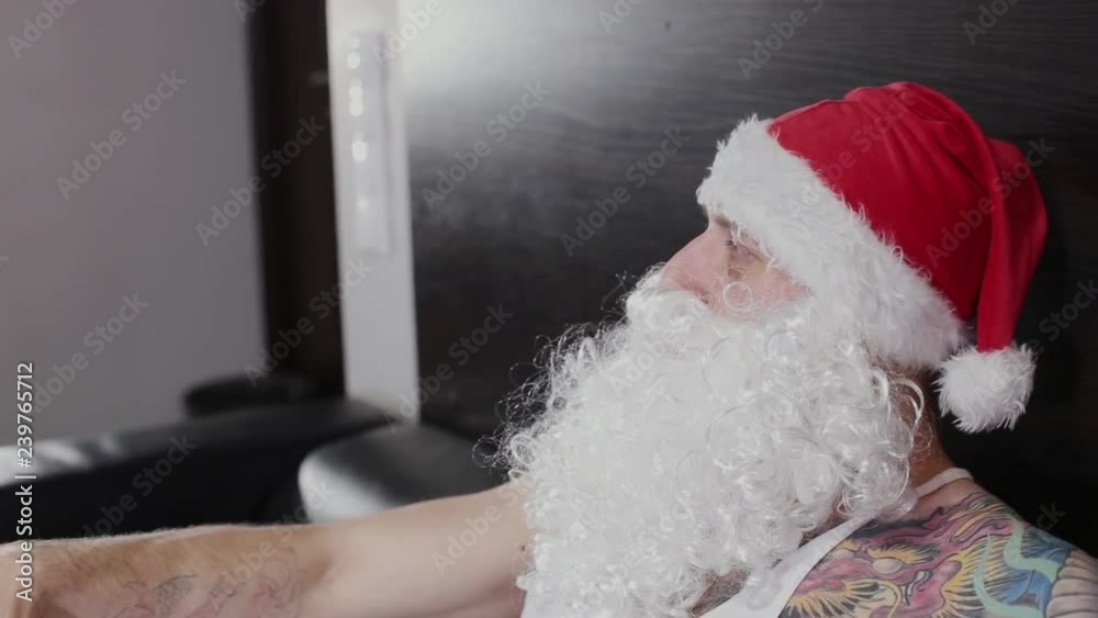 Fitness instructor Santa Claus in the gym resting on a leather sofa. Fitness instructor Santa Claus in the gym resting on a leather sofa.