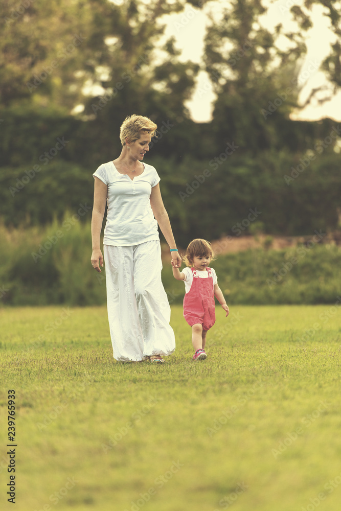 Fototapeta premium mother and little daughter playing at backyard