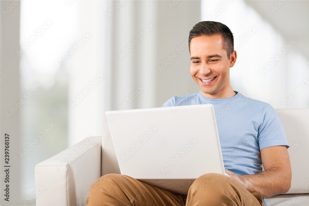 Young man relaxing on the sofa with a laptop Young man relaxing on the sofa with a laptop