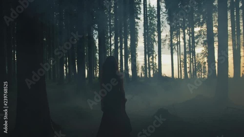 Woman walking in a misty forest