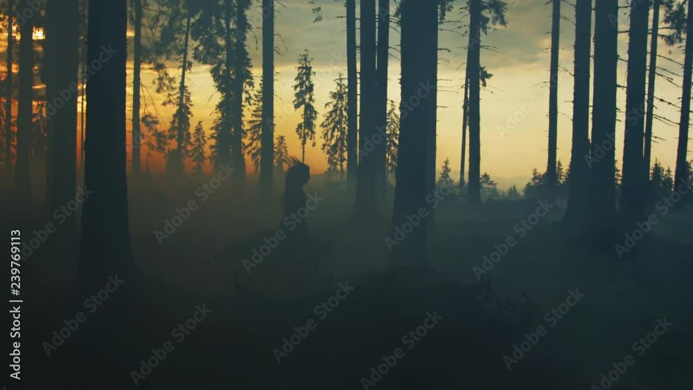 Girl running with a dog in a forest, at sunset