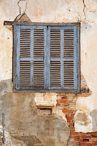 Old Shuttered Window In Cracked Peeling Wall