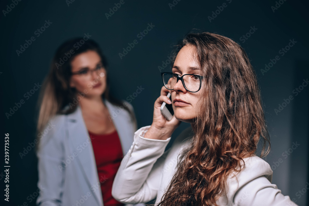 Business two young, successful women. girl is using a smartphone. Business two young, successful women. girl is using a smartphone.