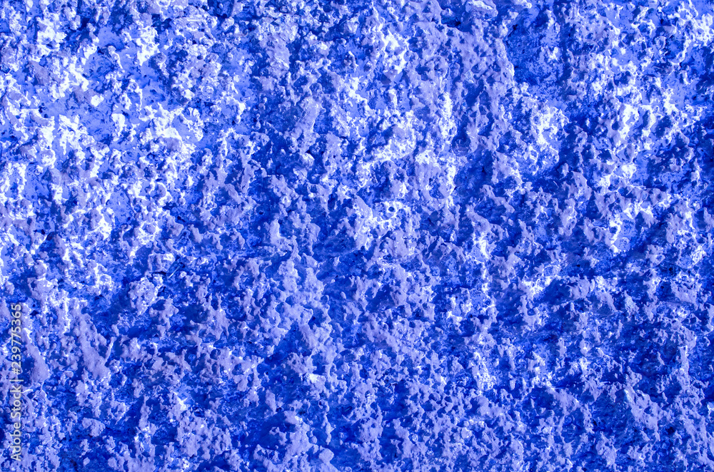 embossed blue wall with white splashes in side lighting embossed blue wall with white splashes in side lighting
