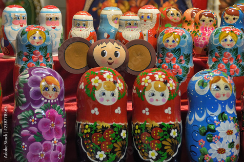 Cheburashka on the background of nesting dolls and figures of Santa Claus in the background