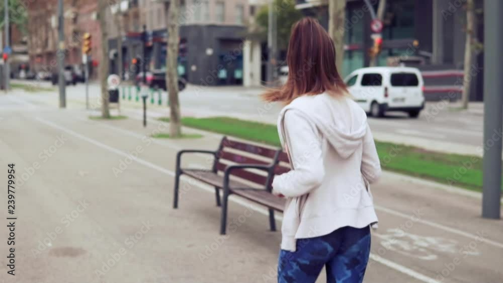 slowmoton shot: woman running in the street of city with buildings in the background. slowmoton shot: woman running in the street of city with buildings in the background.