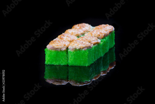 Sushi rolls with salmon, tuna, cucumber and green onions on black background