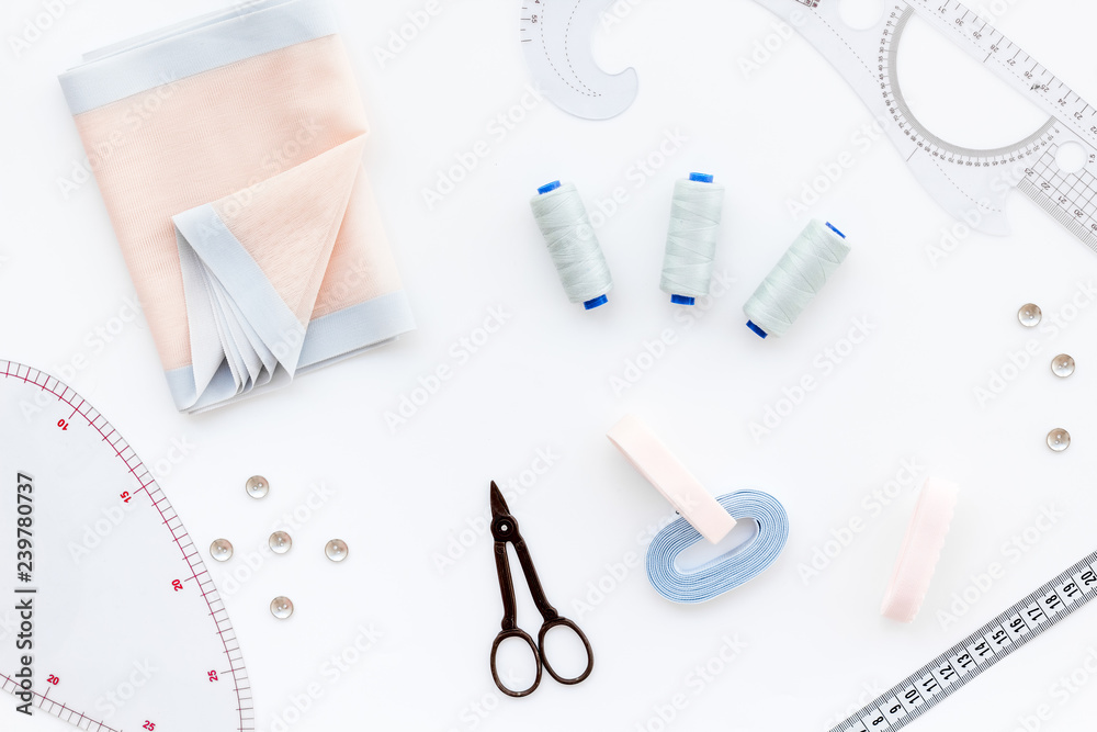 Tailor work place with thread, scissors, fabric. Sewing as hobby. White background top view Tailor work place with thread, scissors, fabric. Sewing as hobby. White background top view