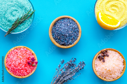 Aromas of bath salt. Lemon, coffee, rosemary, rose, lavender near bowls with colorful bath salt on blue background top view