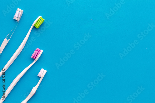 Daily oral hygiene for family. Toothbrush on blue background top view mock up