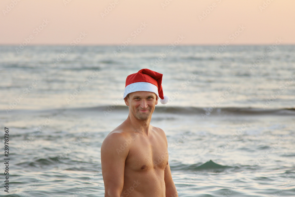 portrait a man in a red Christmas hat against the sea portrait a man in a red Christmas hat against the sea