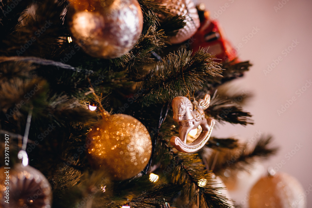 Fototapeta premium Dark Christmas background, closeup New Year ball horse on tree.