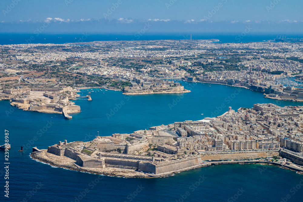 Malta aerial view. Valetta, capital city of Malta, Grand Harbour, Kalkara, Senglea and Vittoriosa towns, Fort Ricasoli and Fort Saint Elmo from above. Marsaxlokk city and Freeport in background