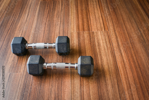Workout equipment on fitness gym floor.Pair of dumbbells weight 3 kilogram each, placed on wooden floor.