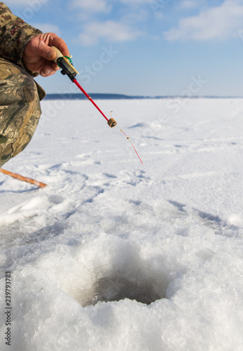 Man catches fish on ice in winter © schankz