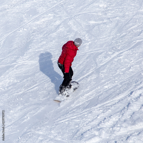 A man snowboarding a mountain in the snow in winter