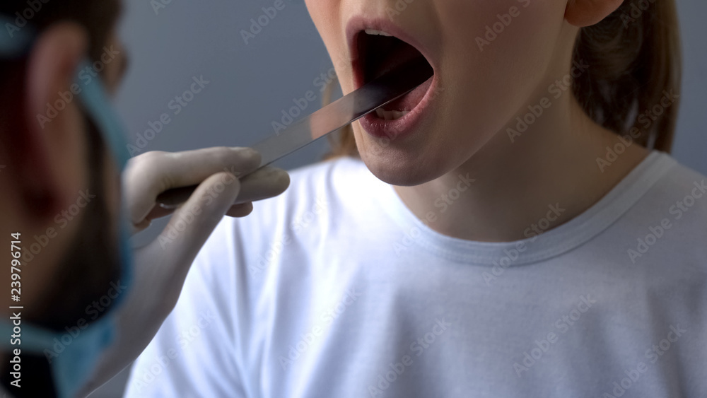 Otolaryngologist checking female patient throat with swollen glands, angina Otolaryngologist checking female patient throat with swollen glands, angina