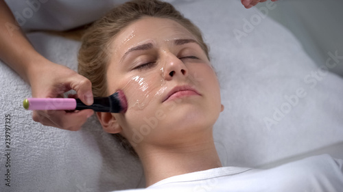Cosmetologist putting alginate mask on client face, moisturizing, skin care
