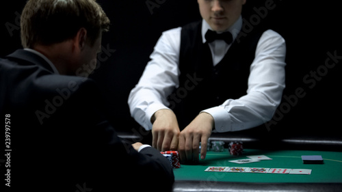 Photography Casino croupier giving businessman all chips for winning at poker, gambling
