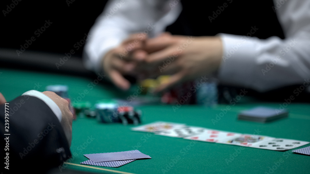 Casino croupier waiting for poker player to reveal cards combination, gambling Casino croupier waiting for poker player to reveal cards combination, gambling