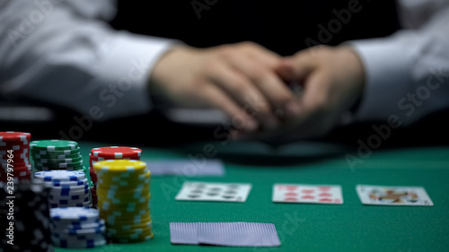 Experienced casino croupier dealing cards in poker game, gambling, close-up