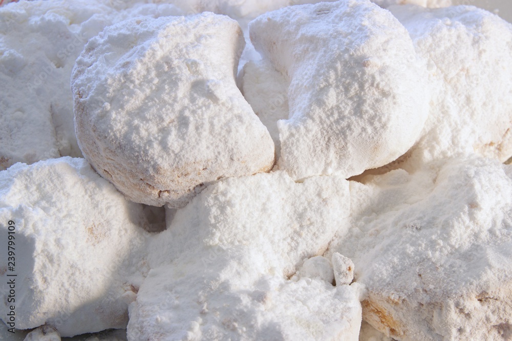 Close up of qurabiya or kourambiethes an almond flavoured crisp buns similar to macaroons a Greek traditional christmas dessert with powdered sugar Close up of qurabiya or kourambiethes an almond flavoured crisp buns similar to macaroons a Greek traditional christmas dessert with powdered sugar