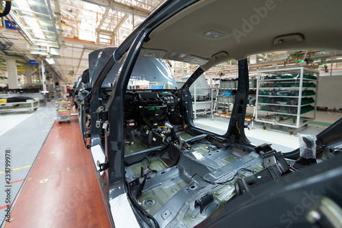 Add details to car body. Robotic equipment makes Assembly of car. Modern car Assembly at factory © Ivan Traimak