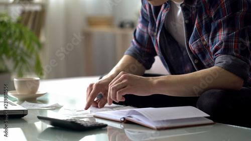 Foto Man checking purchases, holding bill, calculating income and expenses, budget