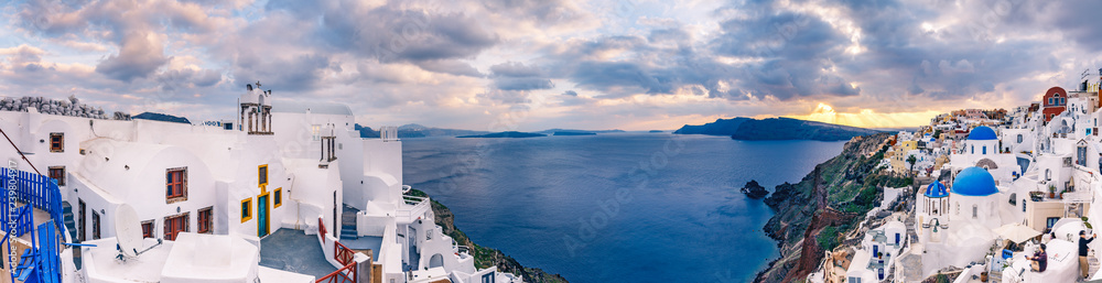 Panorama view on Oia, Santorini island in Greece, at sunset. Scenic travel background.