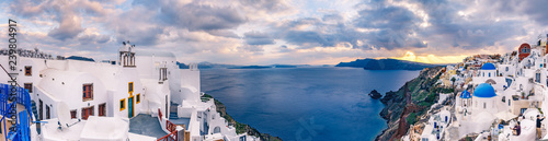 Panorama view on Oia, Santorini island in Greece, at sunset. Scenic travel background.