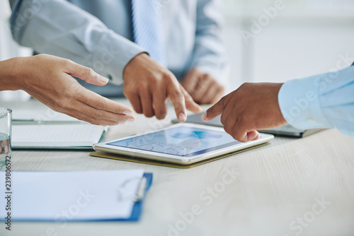 Business partners discussing financial chart of tablet computer at meeting