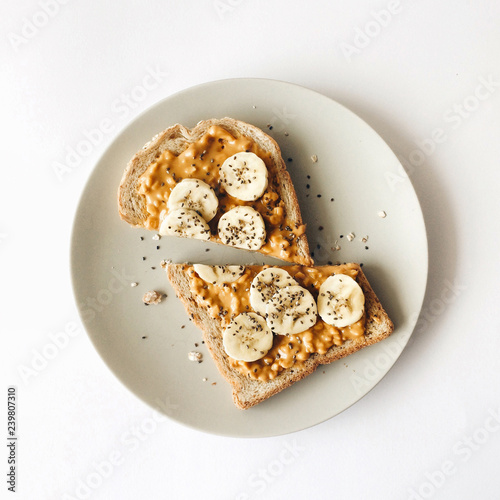 Peanut butter chia seed banana toast for breakfast on a white background, healthy snack, top view