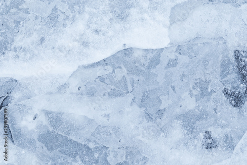 Close-up of snow on cracked and thin layers of ice in the winter. Simple and minimal full frame abstract background. Copy space. © tuomaslehtinen