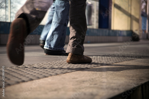 male legs are walking on the sidewalk