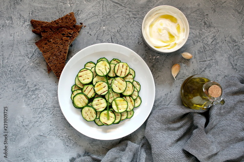 Grilled zucchini salad served with beans, yogurt dip and rye sliced bread. Vegetarian food. Top view. Copy space.