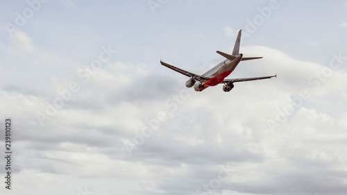 Airplane in the cloudy sky flies away . copy space for text