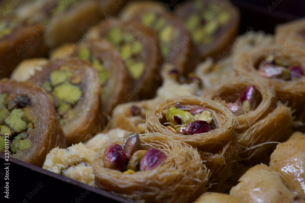 Creative blurred photo of traditional pastry in Middle East country Kingdom of Jordan, traditional arabian sweet pastry baklava close up in artistic blurry background. Jordan, Middle East cuisine Creative blurred photo of traditional pastry in Middle East country Kingdom of Jordan, traditional arabian sweet pastry baklava close up in artistic blurry background. Jordan, Middle East cuisine
