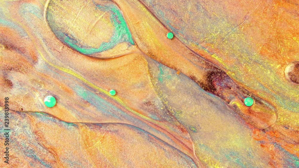 Colorful sparkling paints mix in beautiful patterns. Oil ink of orange, yellow, green and other colors spread on the surface and mix one into another creating amazing textures and design.