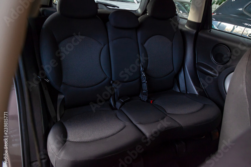 The rear passengers, after cleaning, clean the seats from black expensive fabric in the comfortable cabin of a crossover prepared before selling the car.