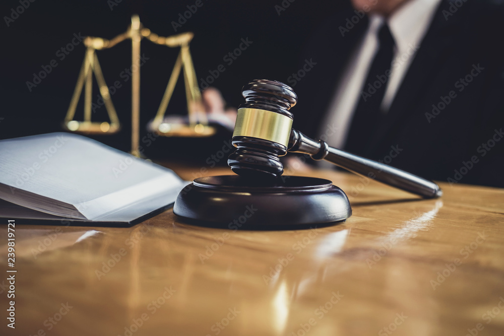 Male lawyer or judge working with contract papers, Law books and wooden gavel on table in courtroom, Justice lawyers at law firm, Law and Legal services concept Male lawyer or judge working with contract papers, Law books and wooden gavel on table in courtroom, Justice lawyers at law firm, Law and Legal services concept