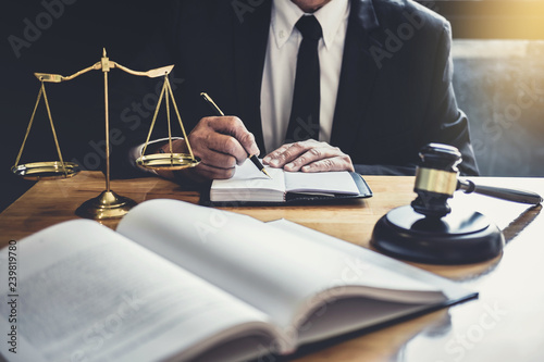 Male lawyer or judge working with contract papers, Law books and wooden gavel on table in courtroom, Justice lawyers at law firm, Law and Legal services concept photo