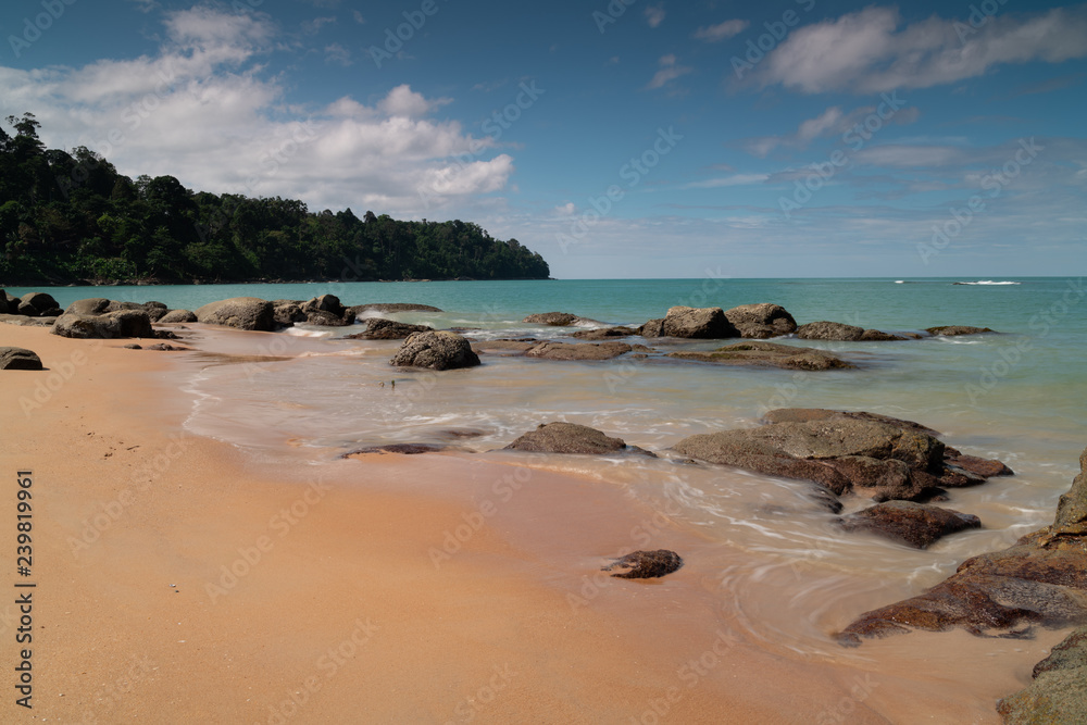 Khao Lak beach, long exposure of waves breaking on rocks and the shore